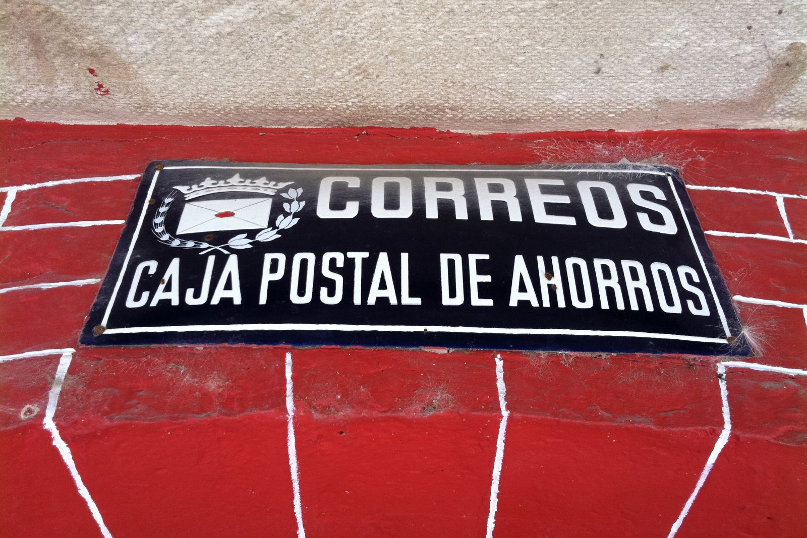 Placa de Correos y Caja Postal de Ahorros en una fachada de Borgonyà